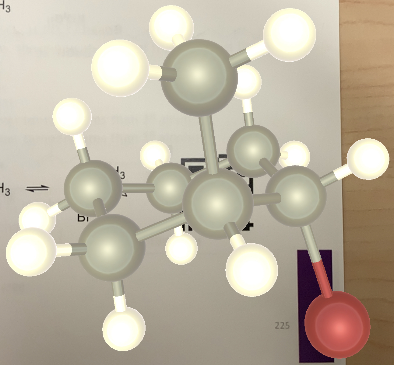 Molecular 3D shapes over a piece of paper with an organic chemistry diagram